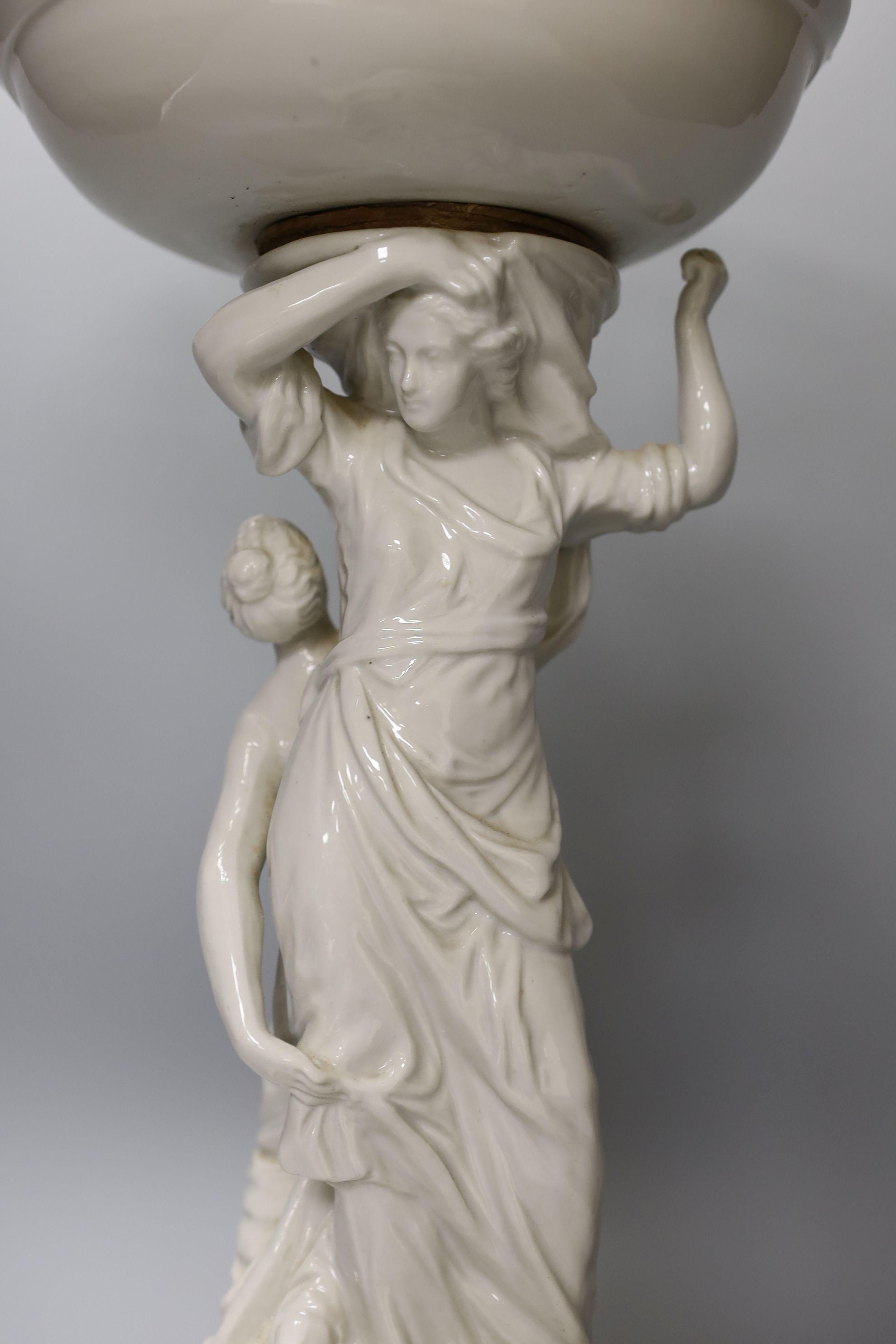 A Continental white glazed porcelain centrepiece bowl modelled with two maidens - 47cm tall